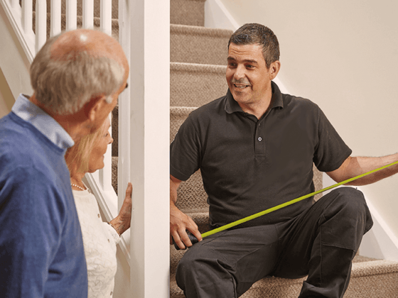 Man measuring out the stair case for a curved stairlift in Penhook, VA